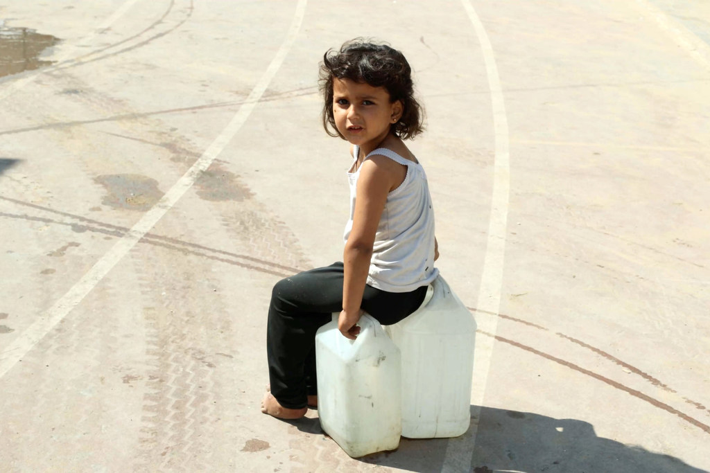 فتاة صغيرة تنتظر الحصول على مياه الشرب في غزة.